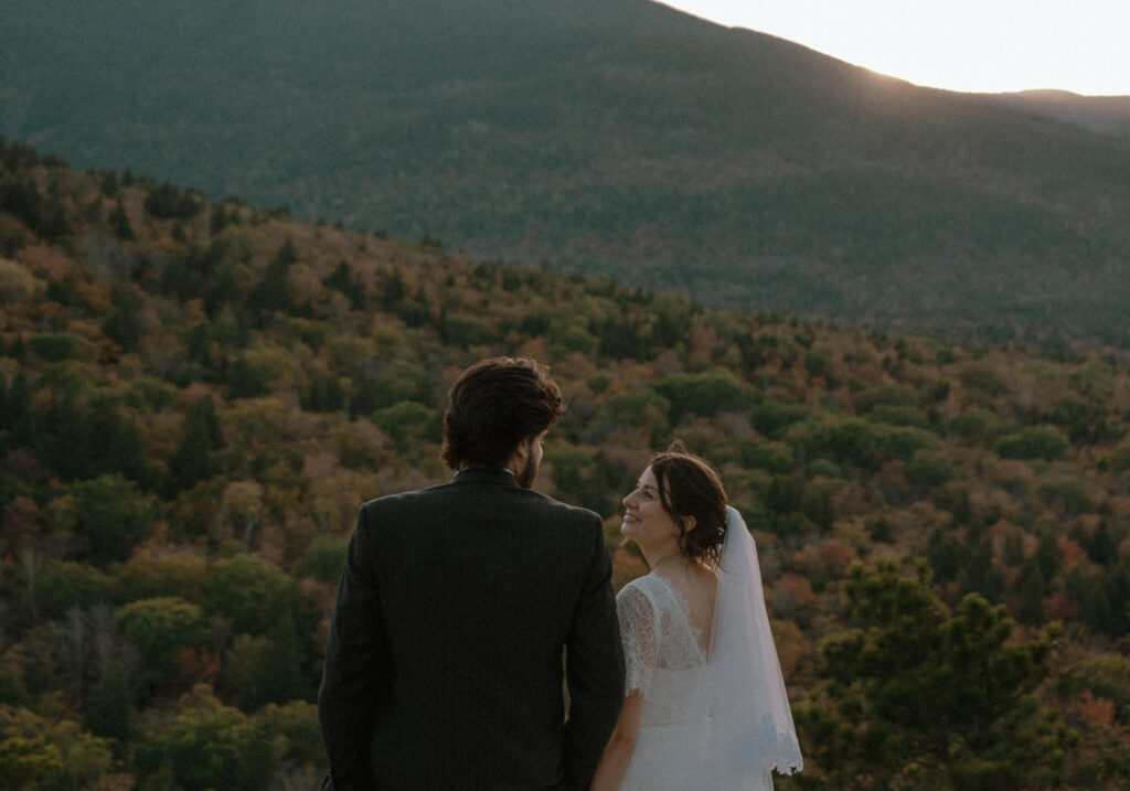 Sunset vows in the White Mountains. During their elopement day in New Hampshire they enjoyed sunset at the top of cathedral ledge.