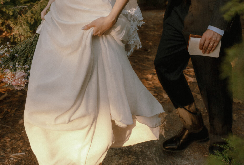 bride and groom walking through a path to their vow spot during their new hampshire elopement with no hiking.