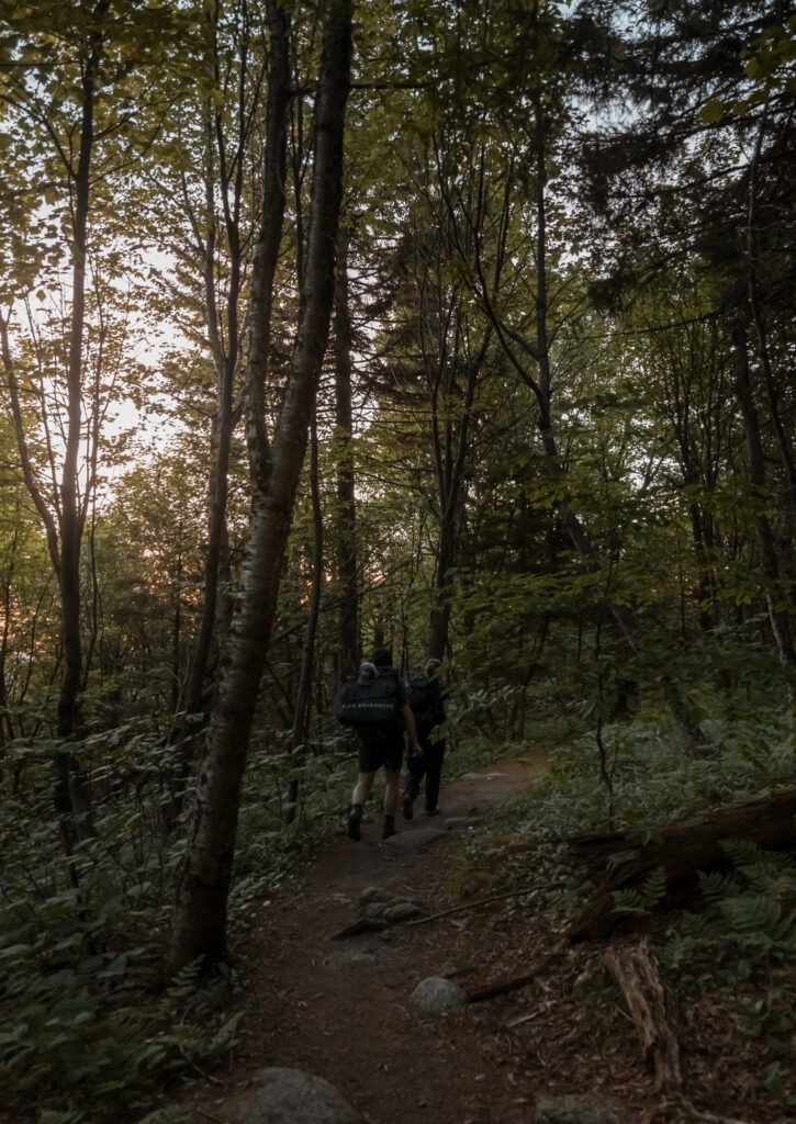 Bride and groom hiking up the trail to get to their sunrise elopement in the white mountains