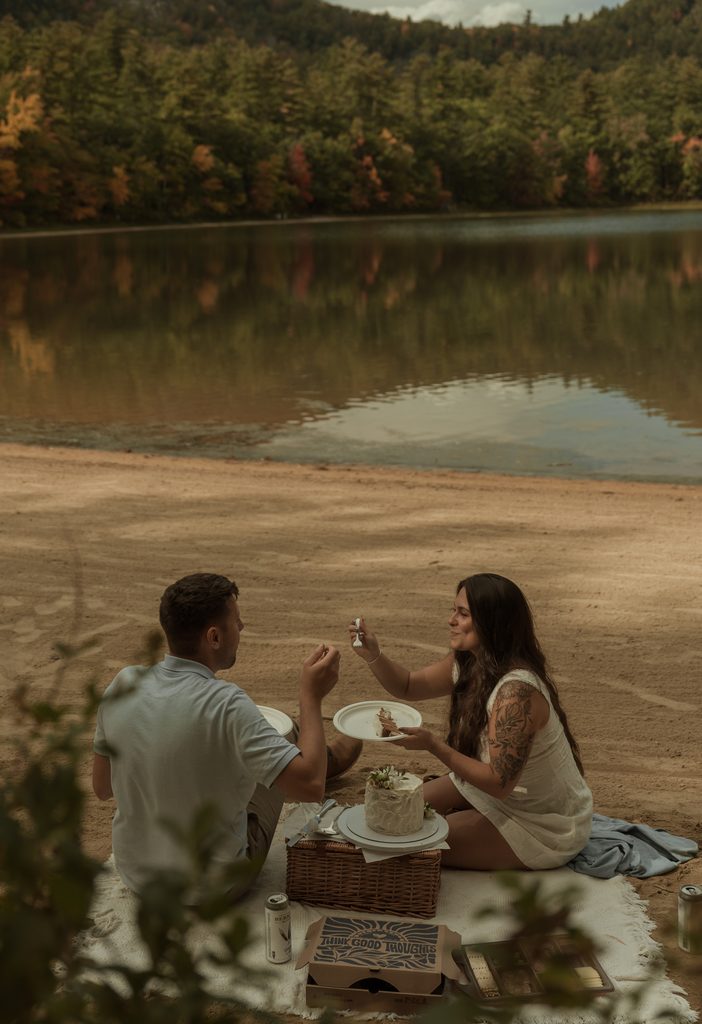 Couple sharing a private picnic before exchanging vows during their New Hampshire fall elopement
