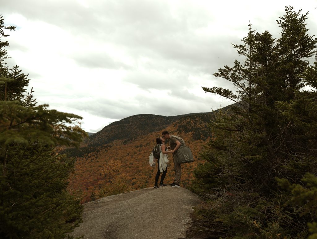 Couple hiking through the White Mountains during their adventurous New Hampshire fall elopement